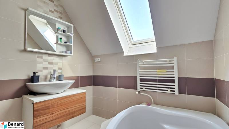 Modern bathroom with a bathtub and a skylight in a 4-room apartment.