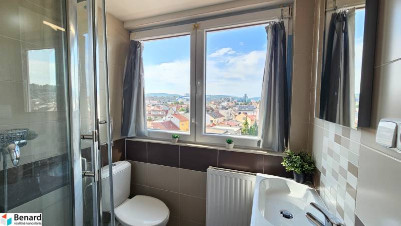 A bathroom in a 4-room apartment with a window and a view of the city.