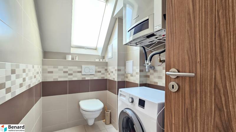 Bathroom in a 4-room apartment with a washing machine, suspended toilet, and skylight.
