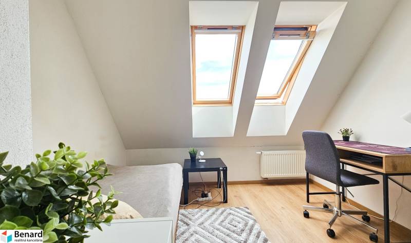 An attic workspace with skylights, a desk, and a chair in a 4-room apartment.