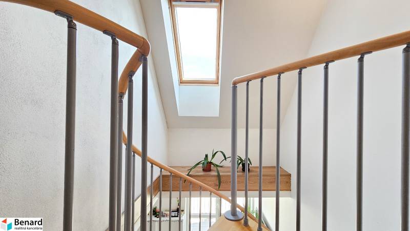 A staircase with a wooden railing and a skylight in a 4-room apartment.