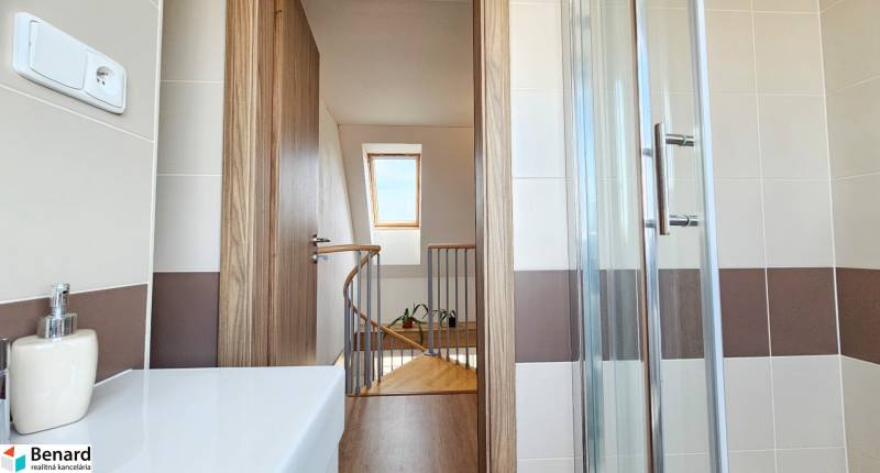 Bathroom with a shower, wooden door, and a view of the staircase in a 4-room apartment.