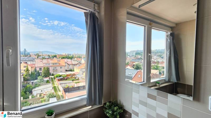 A view from the bathroom to the city, a 4-room apartment with a flower on the window.