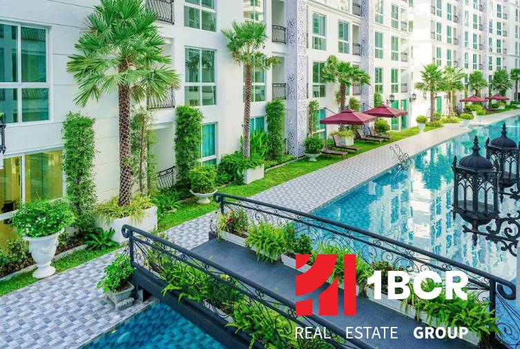 Apartment construction in Pattaya with a swimming pool, greenery, balconies, and outdoor relaxation areas.