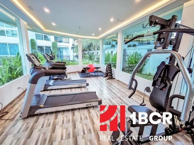 Interior fitness room with exercise machines in a residential building.