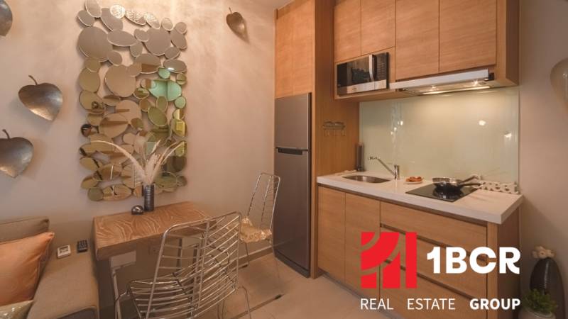 A kitchen in a 2-room apartment with a mirror and gray chairs.