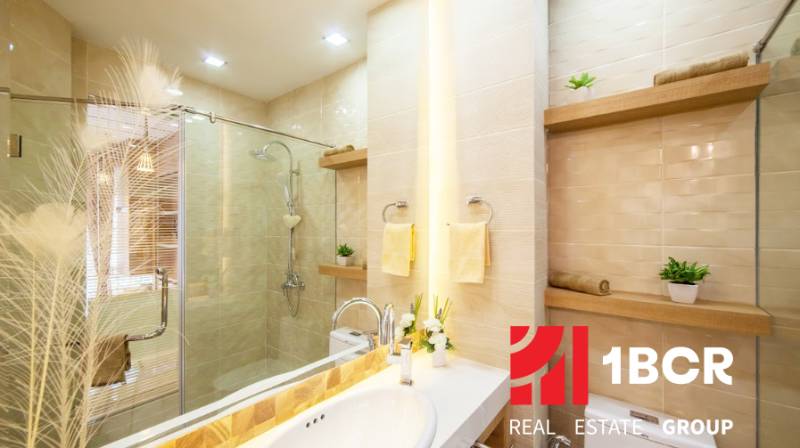 Elegant bathroom in a 2-room apartment with a shower and decorative lighting.