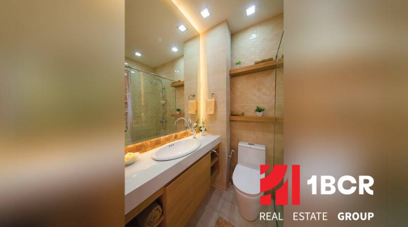 Bathroom in a 2-room apartment with a bathtub, sink, and toilet, wooden and ceramic details.