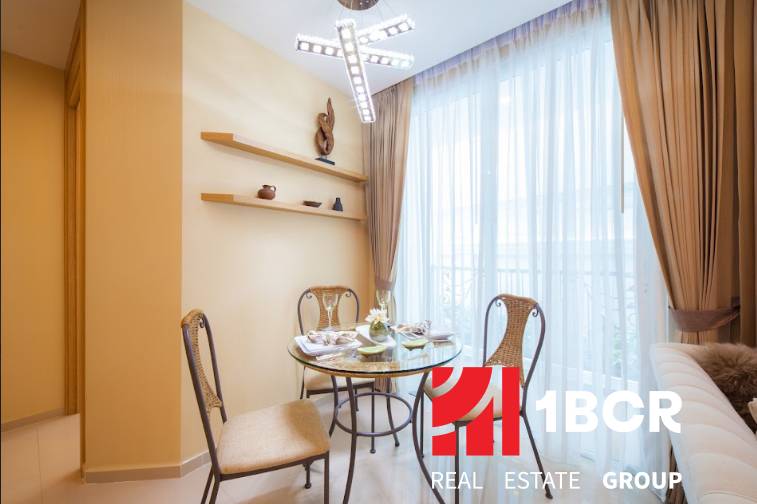 Dining area with a table and chairs in a 3-room apartment, illuminated by a chandelier.
