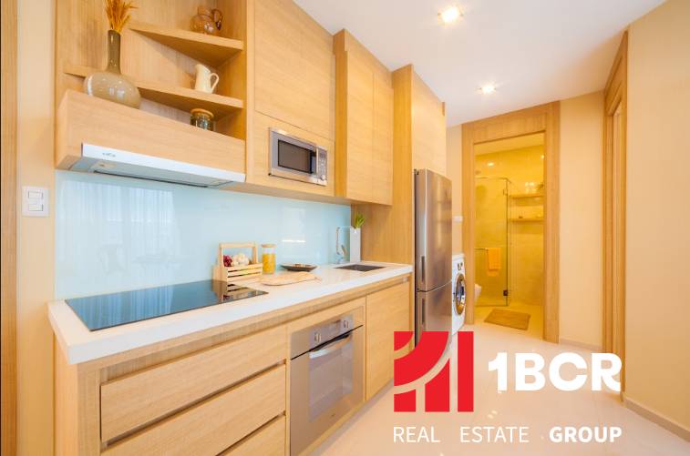A kitchen in a 3-room apartment with wooden cabinets and appliances.