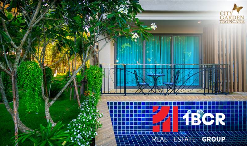 A garden with a swimming pool and seating area under construction in an apartment complex in Pattaya.