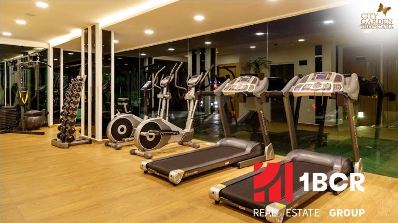Gym with equipment under construction of apartments, treadmills and stationary bikes.