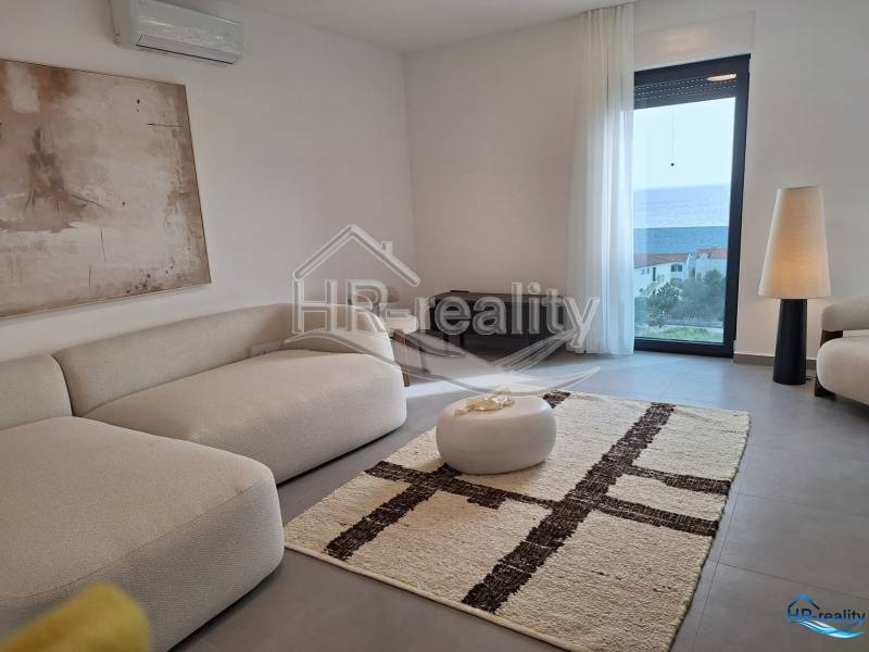 Recreational apartment with comfortable seating, large window, and sea view.