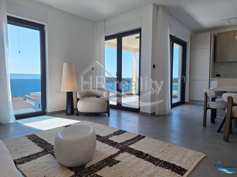 A bright interior of a holiday apartment with a sea view and comfortable seating.