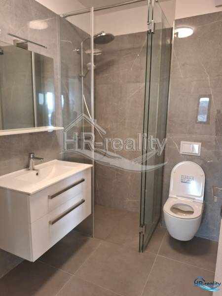 Bathroom in a holiday apartment with a modern shower and mirror.