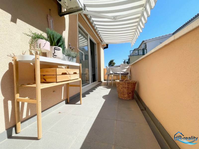 Terrace of a recreational apartment in Šolta with furniture, decorative plants, and a sun awning.