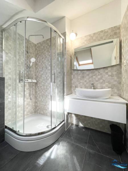 Bathroom in a holiday apartment with a modern shower and sink.