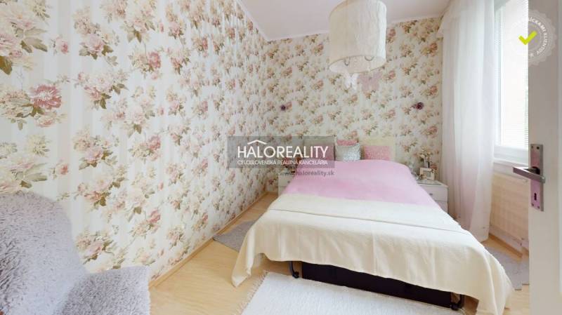 A bedroom in a 4-room apartment with floral wallpaper and a bed.