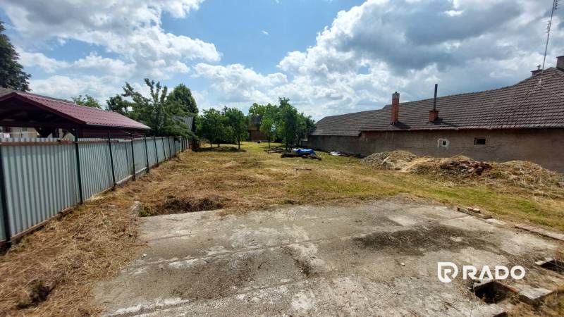 A plot in Chocholná-Velčice for residential purposes with a grassy area and auxiliary buildings.