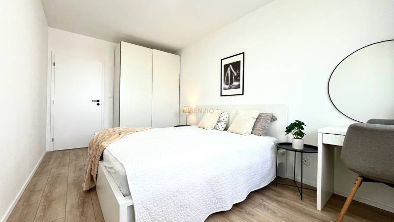 Bright bedroom with a bed, wardrobe, and desk in a 2-room apartment.