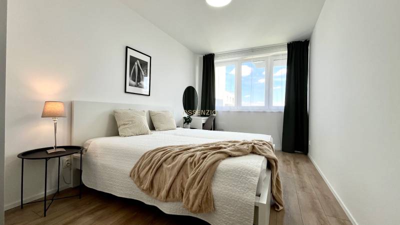 Bright bedroom in a 2-room apartment with two beds and a window.