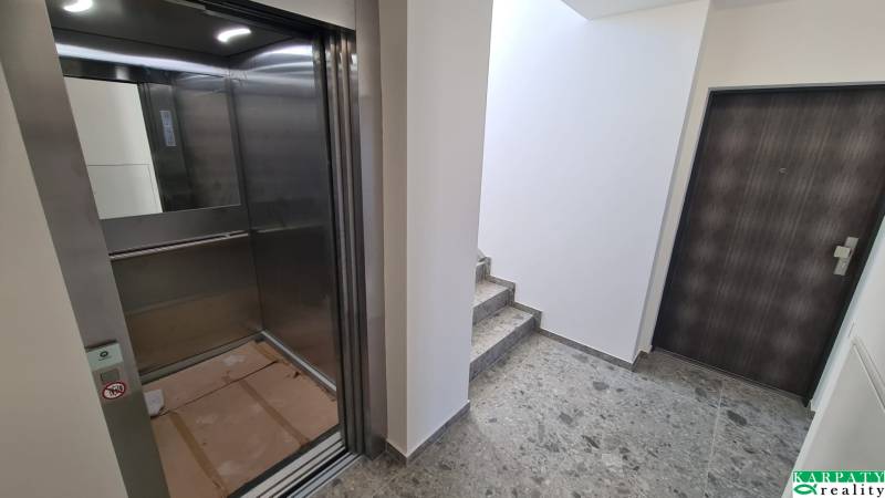 Hallway with an elevator and entrance doors in an apartment building.