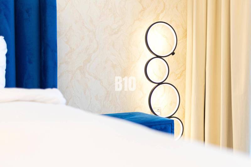 A wall lamp with circular frames by the hangers in a 3-room apartment.
