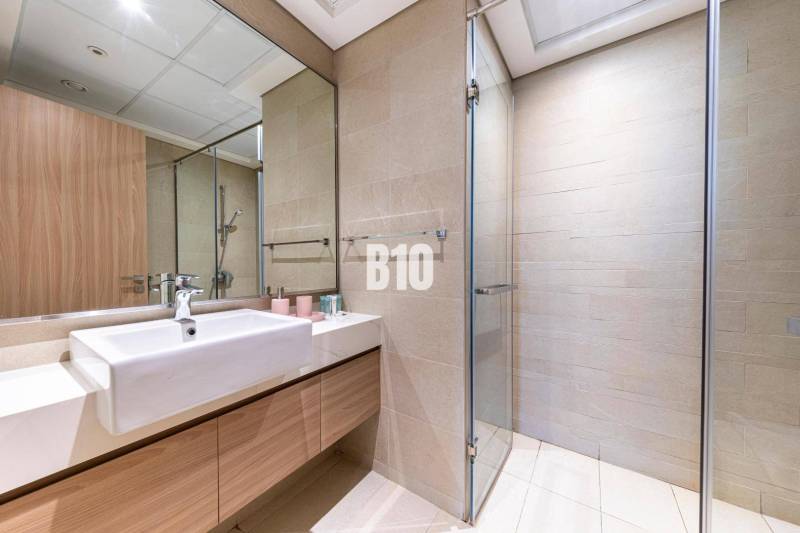 A bathroom with a shower and a mirror in a 3-room apartment.