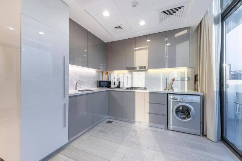 A kitchen in a 3-room apartment with modern appliances and large glass doors.