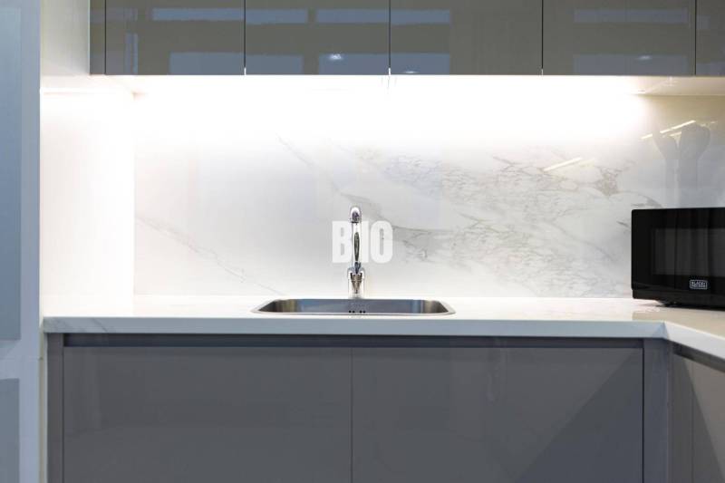 A kitchen unit with a built-in sink and microwave in a 3-room apartment.
