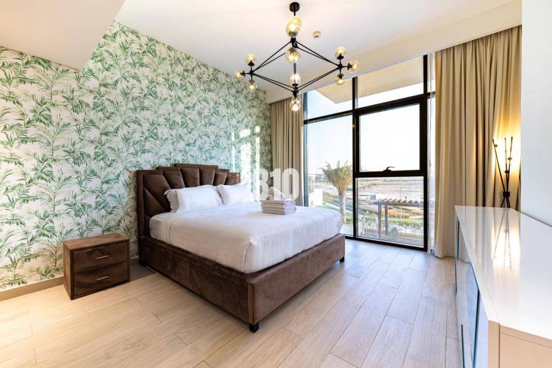 A stylish bedroom with patterned wallpaper and a spacious window in a three-room apartment.