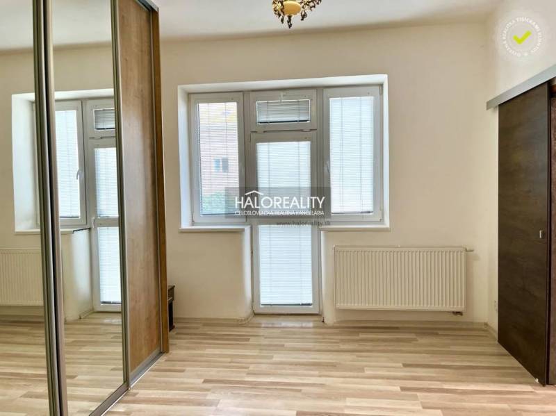 A room in a 3-room apartment with a window and balcony door, built-in wardrobe, light parquet flooring.