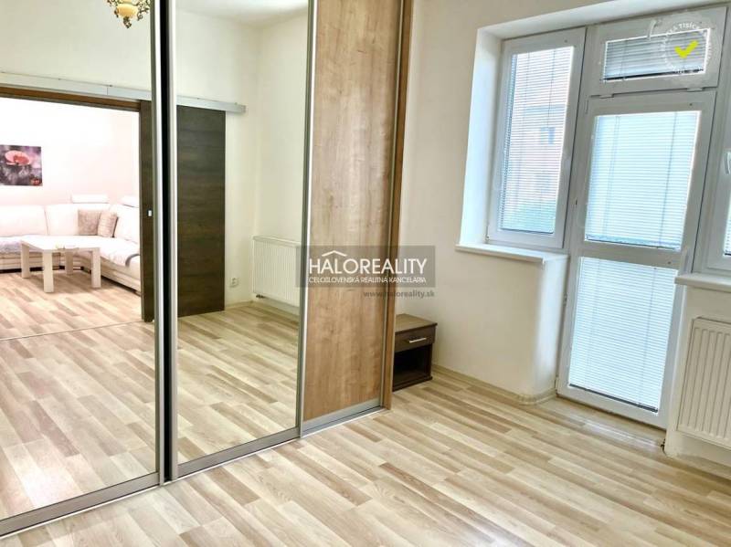 3-bedroom apartment with laminate flooring, a large mirror, and white walls.