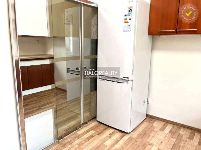 A kitchen with a built-in wardrobe and a refrigerator in a 3-room apartment.
