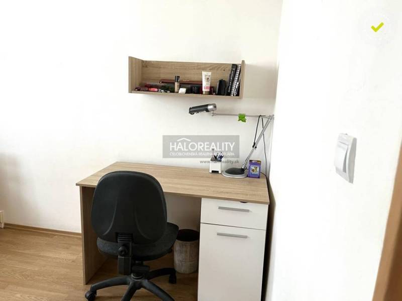 A desk with a shelf and an office chair in a 3-room apartment.