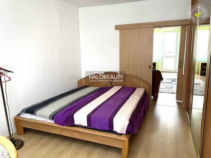 Bedroom in a 3-room apartment with a wooden bed and built-in wardrobes.