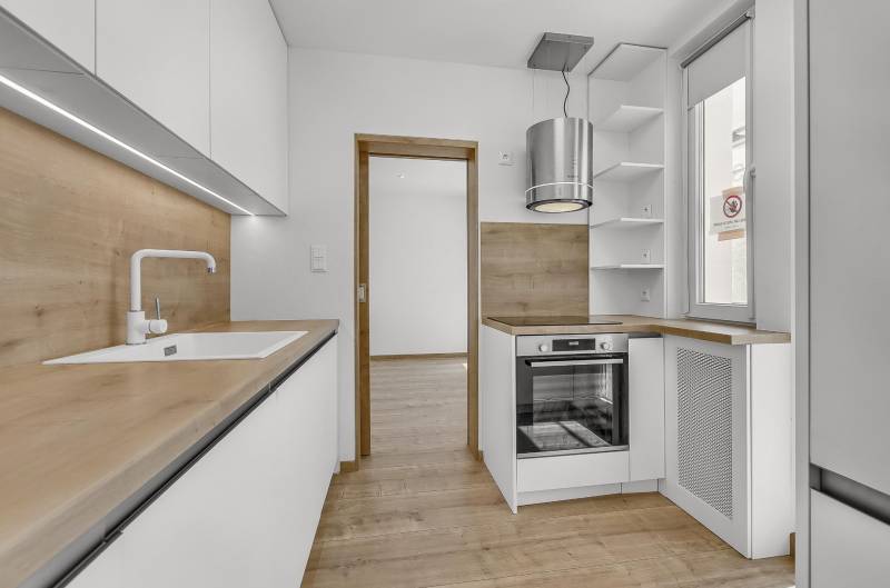 A kitchen with wooden details and built-in appliances in a 4-room apartment.