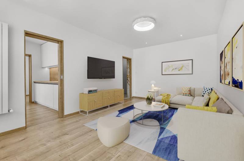 Living room with a sofa, paintings, and a television in a 4-room apartment.