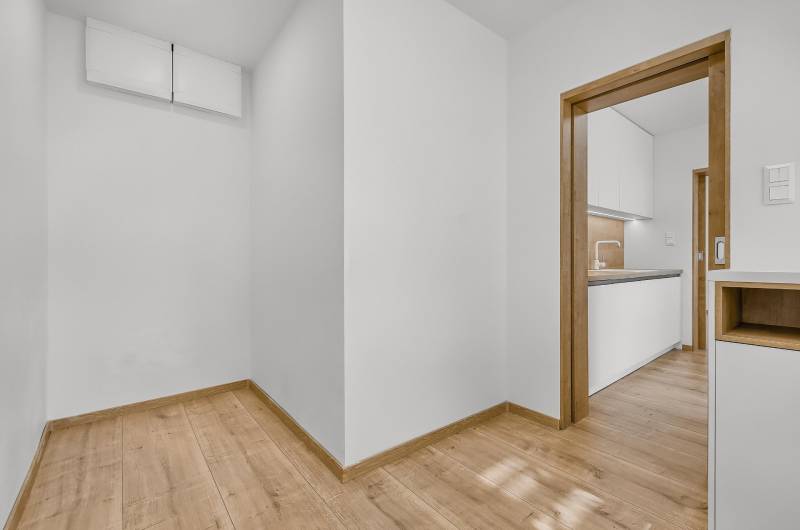 Interior of a 4-room apartment with wooden flooring and a transition to the kitchen.