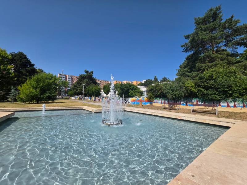 Fountain and benches surrounded by greenery on Landau Street in Bratislava - Dúbravka.