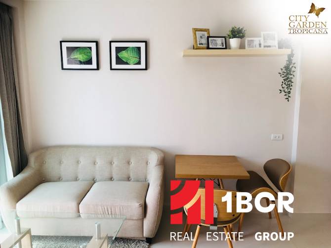 Living area of a 2-room apartment with a sofa, table, and wall decorations.