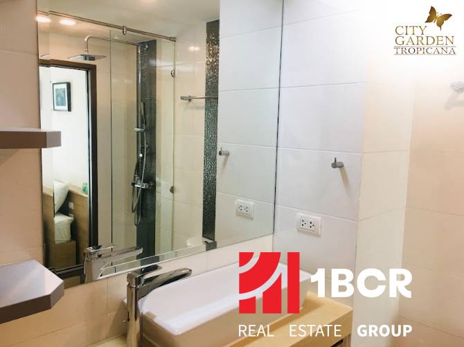 A bathroom in a 2-room apartment with a modern shower and sink.