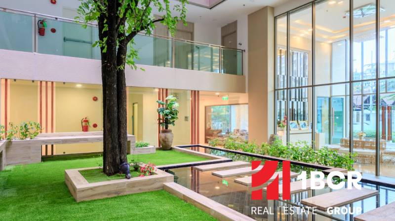 Interior with a spacious garden, lawn, and water features in the construction of apartments.