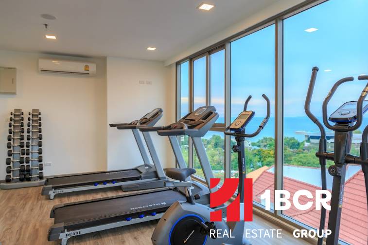 A gym with treadmills and dumbbells, sea view. Apartment construction.