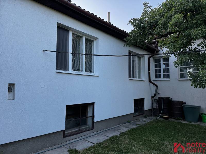 A family house in Lučenec with a white facade, a garden, and large windows.