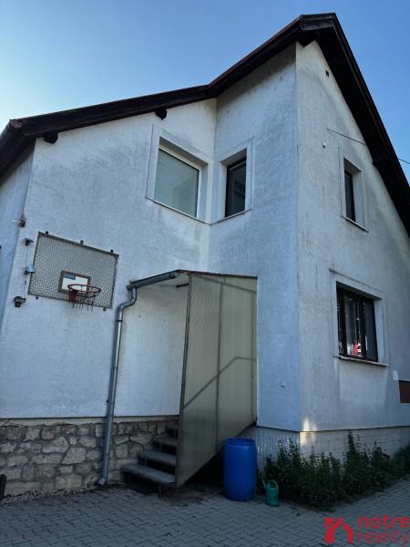 A family house in Lučenec with an elevated entrance and a basketball hoop.