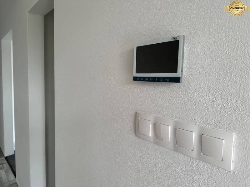 In the family house, there are light switches and a digital display located on the wall.