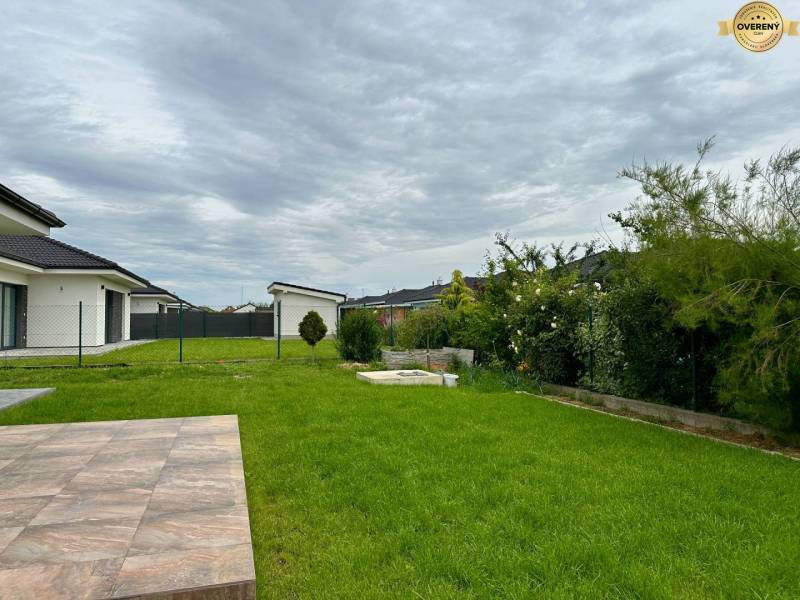 The garden at the family house on Nevädzová Street in Kalinkovo with a green lawn and a terrace.