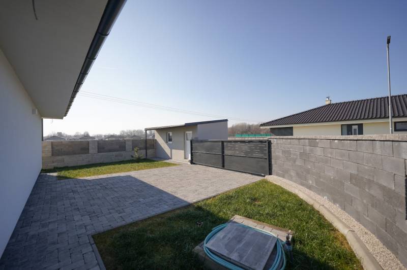 The yard of a family house on Nevädzová Street in Kalinkovo with a lawn and interlocking paving.