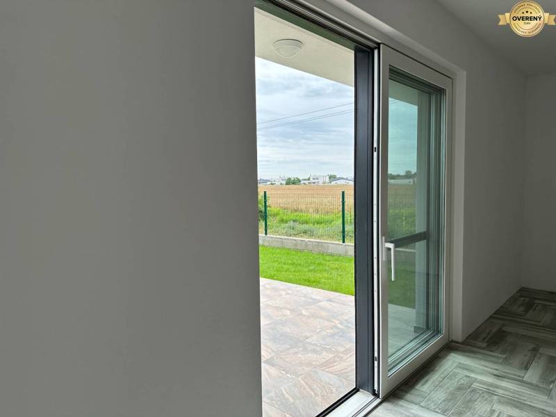 The interior of a family house with a view of the garden through large glass doors.